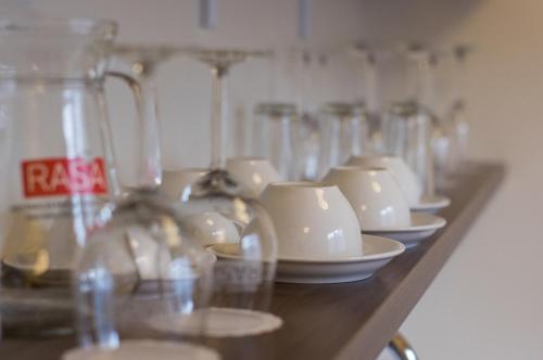 a row of glass vases and cups on a shelf at Goda Hotel & Spa in Druskininkai