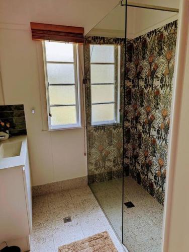 a shower with a glass door in a bathroom at 3 bed cottage nestled at centre of 21 acres in Blackbutt in Blackbutt