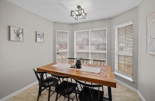 a dining room with a wooden table and chairs at Modern Home Close to It All in DFW Texas! in Grand Prairie