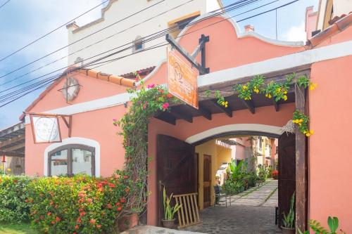 an entrance to a pink building with flowers at Caribbean Breeze 6A Condo in Roatán
