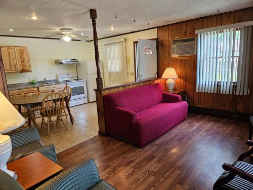 uma sala de estar com um sofá roxo e uma cozinha em The Gold Eagle em Lake George