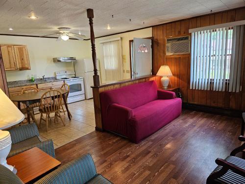 a living room with a purple couch and a kitchen at The Gold Eagle in Lake George