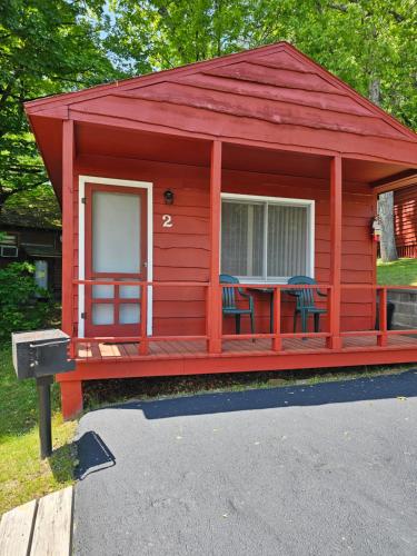 a red cabin with a table and chairs in it at The Gold Eagle in Lake George