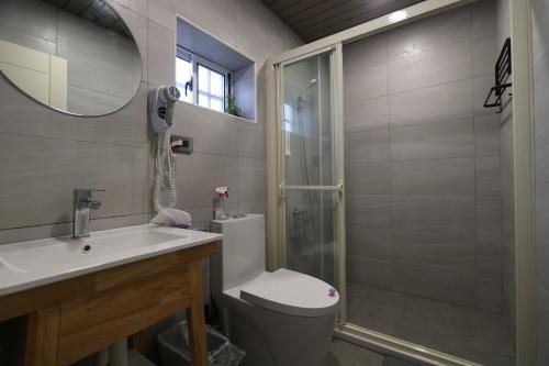 a bathroom with a shower and a toilet and a sink at 微光書旅-輕旅 in Tongluo