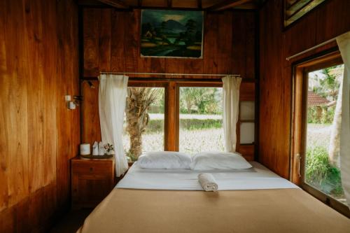 a bed in a room with a window at Puri Sunny Camp in Munduk