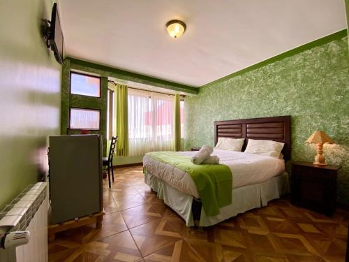 a bedroom with a bed with a green wall at Las Tholas Hotel in Uyuni