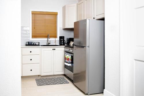 a kitchen with a stainless steel refrigerator and white cabinets at Sheer Bliss BeachView Apt #1 in Georgetown