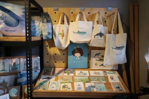 a display of bags and books on a shelf at 微光書旅-輕旅 in Tongluo