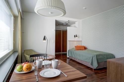 a room with a table and a bedroom with a bed at Forenom Serviced Apartments Espoo Tapiola in Espoo