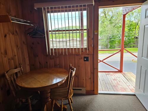 a wooden table and chairs in a room with a door at The Gold Eagle in Lake George