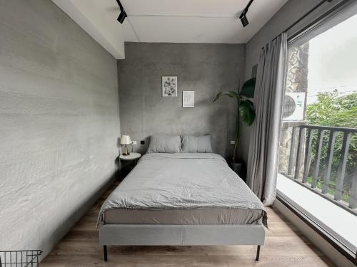 a bedroom with a bed and a large window at hsueh_house in Yilan City
