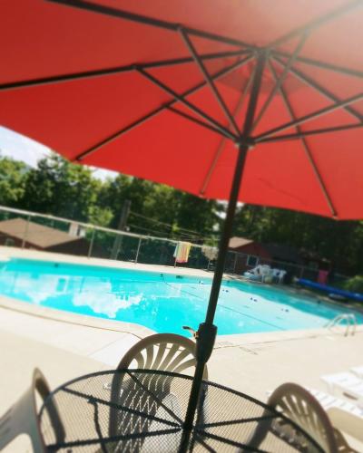 a red umbrella sitting next to a swimming pool at The Gold Eagle in Lake George