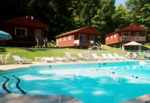 a swimming pool with chairs and a house in the background at The Gold Eagle in Lake George