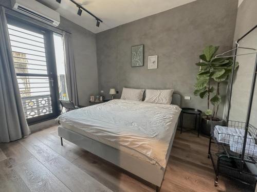 een slaapkamer met een bed en een groot raam bij hsueh_house in Yilan