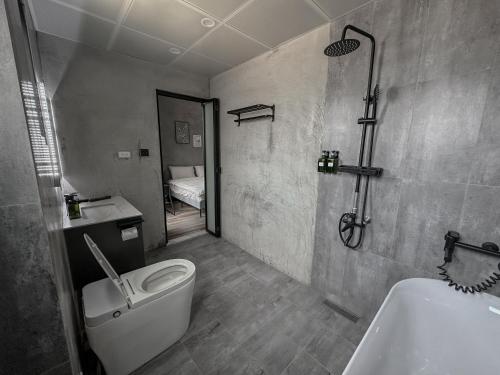 a bathroom with a toilet and a sink and a shower at hsueh_house in Yilan City