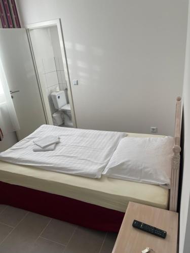 Cama en habitación con espejo en Pension-Wob 2, en Wolfsburg