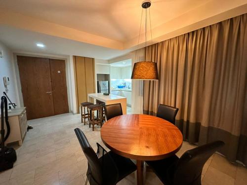 a dining room with a wooden table and chairs at MyHabitat - KLCC 2 bedroom in Kuala Lumpur