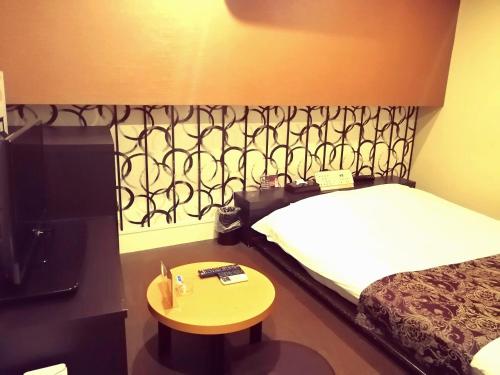 una camera d'albergo con letto e tavolino di HOTEL WILL渋谷 LOVE HOTEL -Adult only- a Tokyo