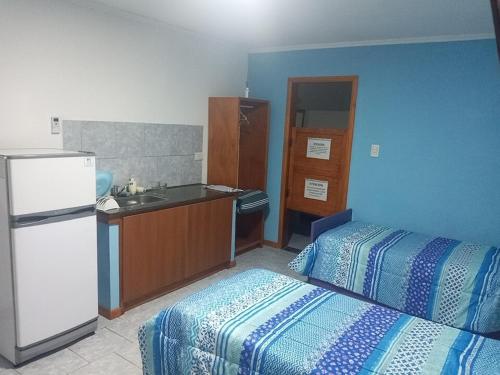 a room with a kitchen with a bed and a refrigerator at 365 Dptos in Villa Regina