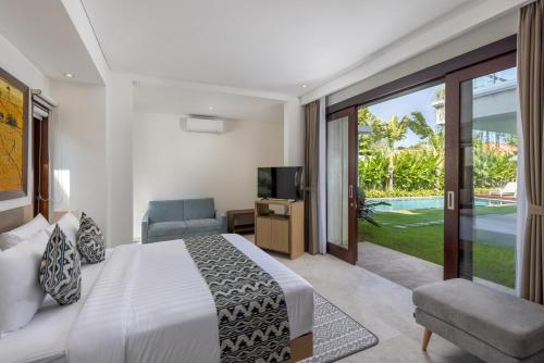 a bedroom with a bed and a sliding glass door at Villa UmaDahayu in Sanur