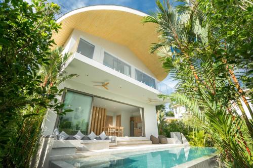 Himmapana Villas - Hills في شاطئ كامالا: منزل به مسبح بجانب مبنى