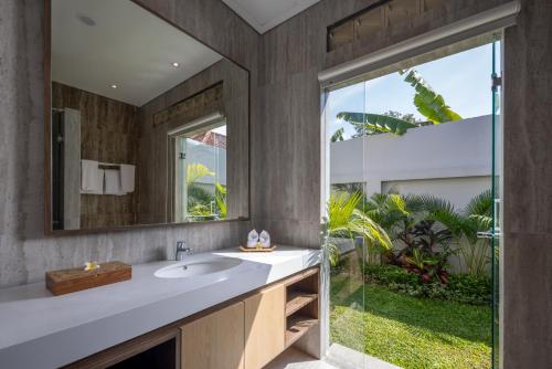 a bathroom with a sink and a large window at Villa UmaDahayu in Sanur