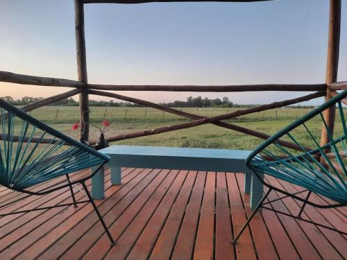 two chairs on a deck with a view of a field at Cabañas Jamakimel in Uribelarrea