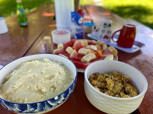 une table avec des bols de nourriture et une assiette de fruits dans l'établissement Pinar del Valle - Glamping en el Bosque - Propiedad Completa en Constanza, à Constanza