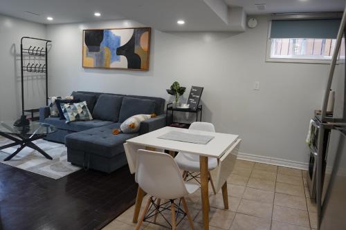 sala de estar con sofá azul y mesa en Patio privé, hébergement équipé et spacieux., en Hamilton