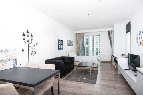 a white living room with a table and a couch at MyRehat Suites Bukit Ceylon in Kuala Lumpur