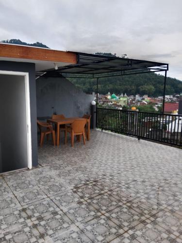 patio con mesa y sillas en el balcón en APUT VILLA RESIDENCE MUTIARA B7, en Songgoriti