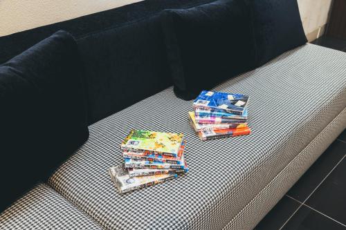two stacks of books sitting on top of a couch at Quintessa Hotel Kokura Comic & Books in Kitakyushu