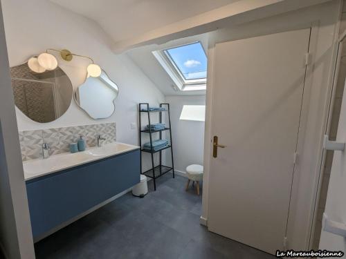 un bagno con lavandino e specchio di Séjour de charme à Mareau-aux-Bois : parc, home cinéma, billard, tennis et télétravail en fibre ultra-rapide - FR-1-590-279 a Mareau-aux-Bois