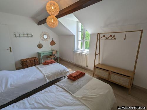 una camera da letto con due letti e una finestra di Séjour de charme à Mareau-aux-Bois : parc, home cinéma, billard, tennis et télétravail en fibre ultra-rapide - FR-1-590-279 a Mareau-aux-Bois