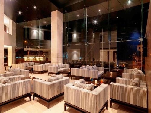 a lobby with couches and tables in a building at Svenska Design Hotel, Electronic City, Bangalore in Bengaluru