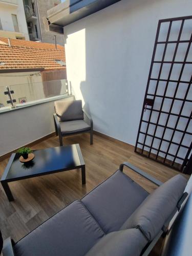 een woonkamer met een bank, een tafel en een stoel bij Angel House oasi in Catania
