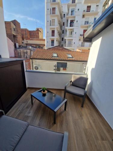een balkon met een bank, een tafel en een stoel bij Angel House oasi in Catania