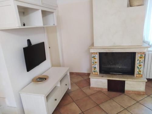 een woonkamer met een open haard en een televisie bij Casa Forola Holiday House in Acquaviva Picena