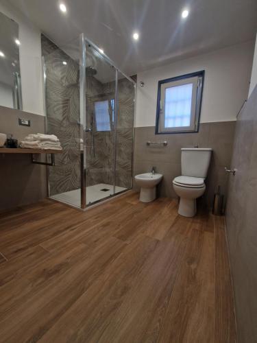 een badkamer met een toilet en een glazen douche bij Angel House oasi in Catania
