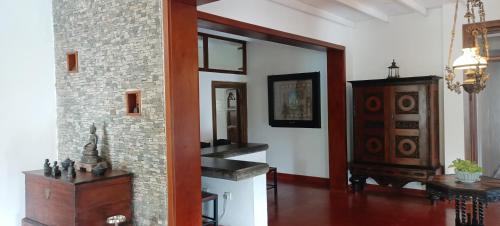 Kaya Residence Kandy في كاندي: غرفة معيشة مع جدار من الطوب وعلبة درج