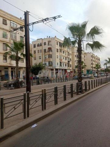 a city street with a fence and palm trees at appartement TAza in Casablanca