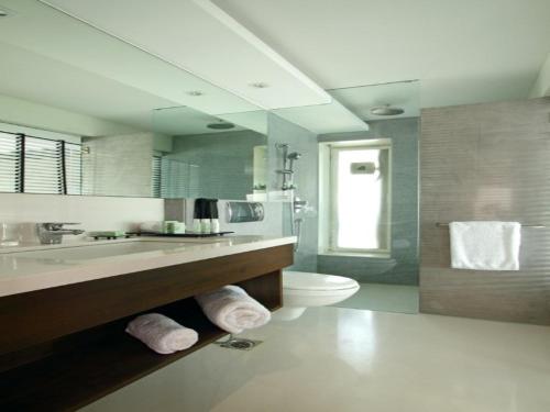 a bathroom with a sink and a toilet and a mirror at Svenska Design Hotel, Electronic City, Bangalore in Bangalore