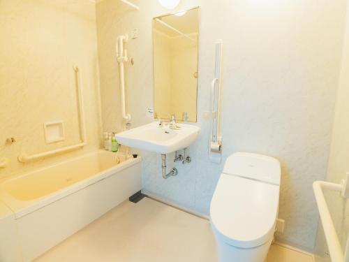 Quintessa Hotel Kokura Comic & Books في كيتاكيوشو: حمام مع حوض ومرحاض وحوض استحمام
