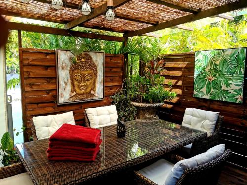 a table and chairs on a patio with aitating at Hôtel Fenua Mata'i'oa in Papetoai