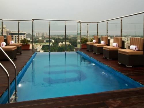a swimming pool on the roof of a building at Svenska Design Hotel, Electronic City, Bangalore in Bengaluru