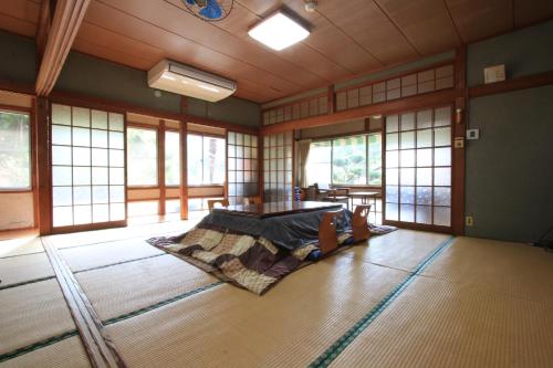 - une chambre avec un lit dans une pièce dotée de fenêtres dans l'établissement Dainichiya-ryokan, à Sasaguri