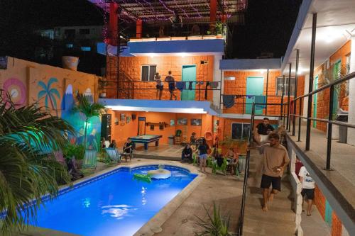 a group of people standing around a swimming pool at Hostel Nirvana Taganga in Taganga
