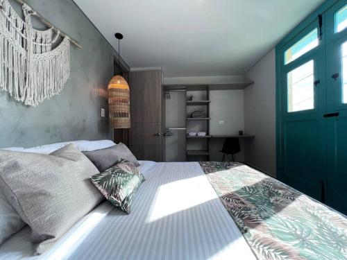 um quarto com uma cama grande e uma porta azul em Parallelo Loft Salento P3 em Salento