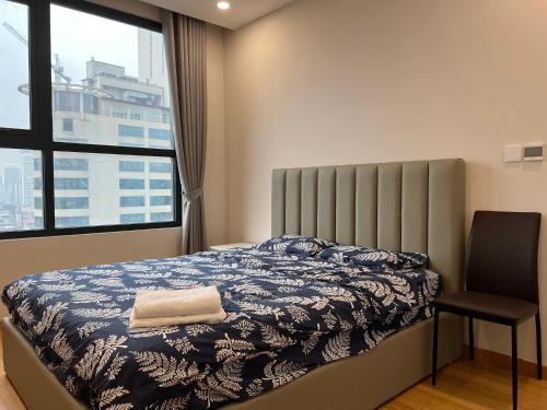 a bedroom with a bed and a chair and a window at Hanah Residence Chuỗi CHDV The Zei Hanoi in Hanoi