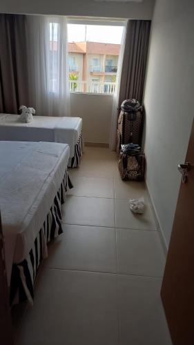 Cette chambre comprend 2 lits et une fenêtre. dans l'établissement Ondas Praia Resort, à Coroa Vermelha